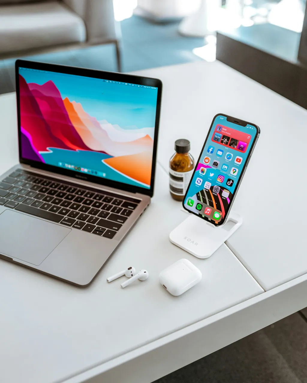 A laptop, phone, and headphones ready to go on a clean desk